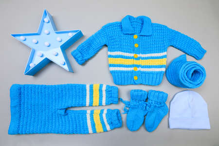 Baby concept. handmade knitted suit for baby on grey  background. Place for text. View from above. Flat Layの写真素材