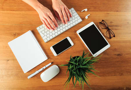 Female hands working on wooden work place with modern gadgets  top view - Image