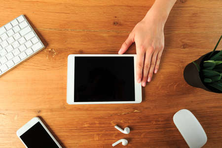 Female hands working with tablet  on work place - top view