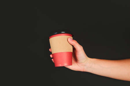female  manicure. Beautiful young woman's hands holding coffee on black backgroundの写真素材