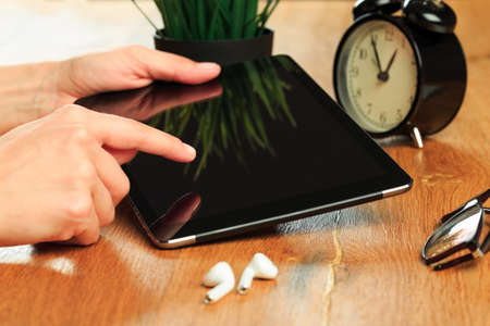 female hands holding tablet on wooden background - Imageの写真素材