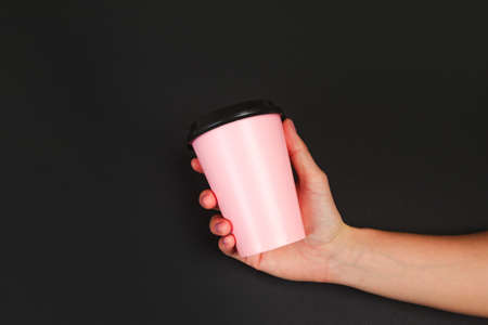 female  manicure. Beautiful young woman's hands holding coffee on black backgroundの写真素材