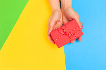 Woman presenting gift box top view on pastel  background .Giving presents concept  for Mother's Day, Women's Day or any other holiday or celebrationの写真素材