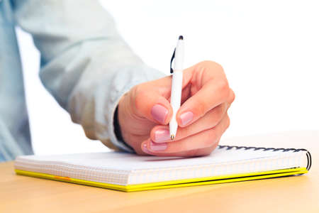 female hands write in a notebook . Office place