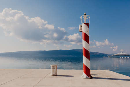 Red and white lighthouse with cloudsの写真素材
