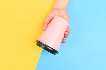 female  manicure. Beautiful young woman's hands holding coffee on pastel pink background