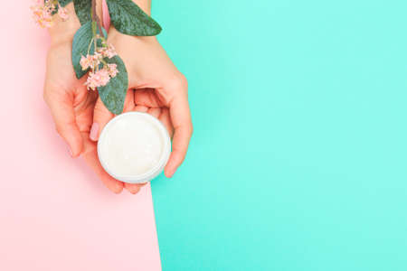 female  manicure. Beautiful young woman's hands with cream  on pastel background - Imageの写真素材