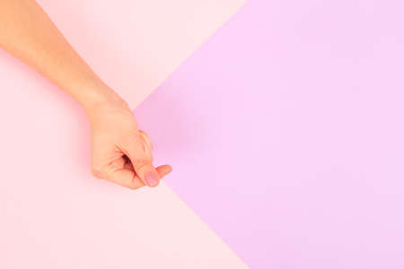 female  manicure. Beautiful young woman's hands in heart shape on pastel pink  backgroundの写真素材