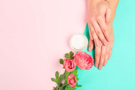 female  manicure. Beautiful young woman's hands with cream  on pastel background - Imageの写真素材