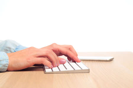 female hands type on a modern wireless keyboard on Office tableの写真素材