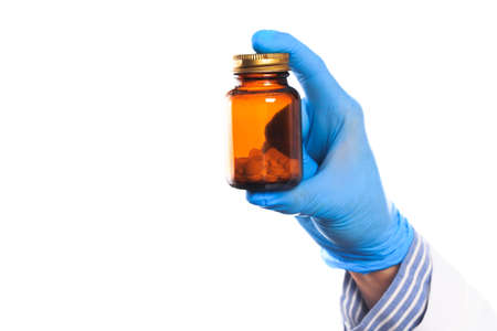 Doctor hand in sterile gloves holding glass vial isolated on white backgroundの写真素材