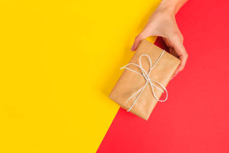 Woman presenting gift box top view on pastel  background .Giving presents concept  for Mother's Day, Women's Day or any other holiday or celebrationの写真素材