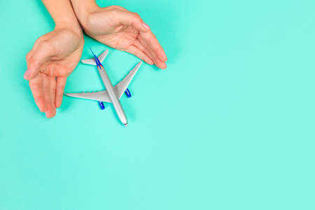 Beautiful young woman's hands holding plane    on pastel  background - Image