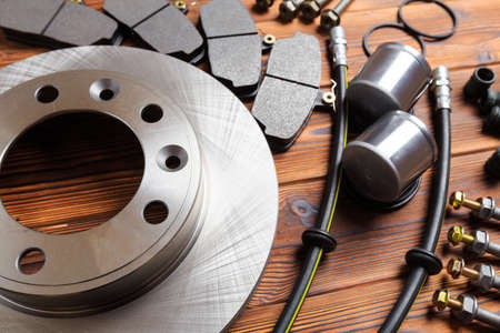 brake parts on wooden background  brake pads, disc, brake hose, guides, cylindersの写真素材
