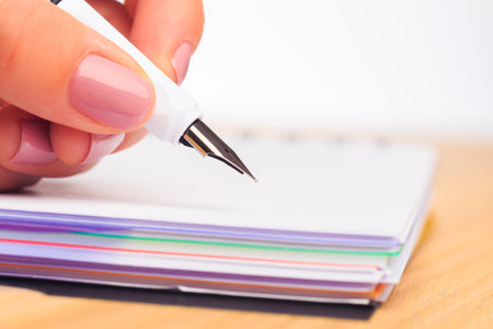 female hands write in a notebook . Office place . Close up viewの写真素材