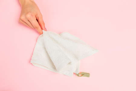 Beautiful young woman's hands with  white care  towel   on pastel pink background - Image
