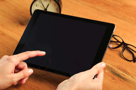 female hands holding tablet on wooden background  , place for your text  - Imageの写真素材