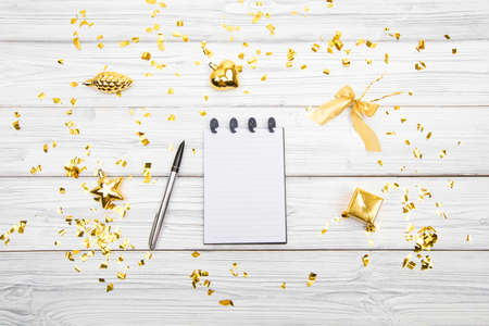 Festive decorations and notebook with wish list on white rustic table, flat lay style. Planning concept.の写真素材