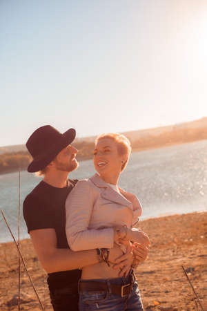 happy couple by the lake at sunsetの写真素材