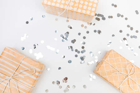 gifts or boxes silver confetti on white table top view. Flat lay composition for birthday, christmas...