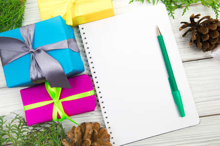 Blank open notepad, pine branches and Christmas decorations on a white wooden table. Space for text. Top view. Flat lay style.の写真素材