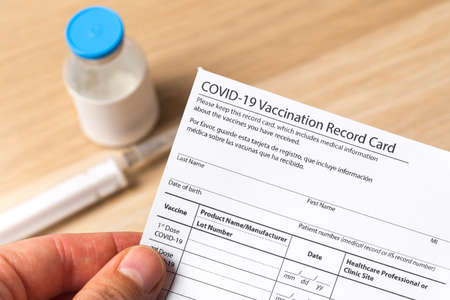 Syringe and vaccine vial for corona virus are on medical form required for travel and tourism.