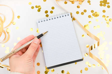 Festive decorations and notebook with wish list on white background , flat lay . Planning concept.