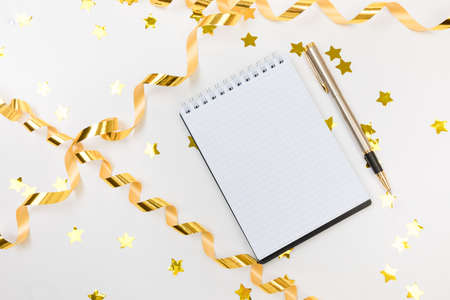 Festive decorations and notebook with wish list on white background, flat lay. Planning concept.の写真素材