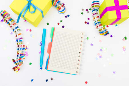 Festive decorations and notebook with wish list on white background, flat lay. Planning concept.の写真素材