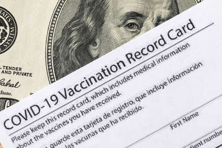 Covid-19 vaccination card and cash moneyの写真素材