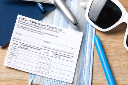 COVID-19 vaccination record card and tourist passport for worldwide travel during coronavirus...