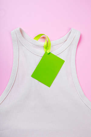 price tag hang over white  t-shirt on  pink background