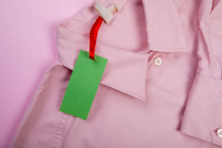 price tag hang over pink shirt close up viewの写真素材