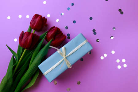 Gift box and spring flowers with confetti on color background. Stylish soft image of spring flowers. Happy women's day. Happy Mothers day.Hello Springの写真素材