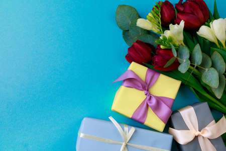 Gift box and spring flowers on color background. Stylish soft image of spring flowers. Happy women's...