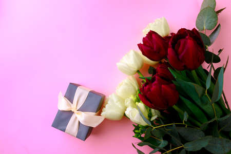 tulips and gift box on pink background. Stylish soft image of spring flowers. Happy women's day....