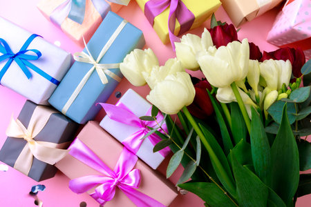 tulips  and gift box on pink background. Stylish soft image of spring flowers. Happy womens day. Happy Mothers dayの写真素材