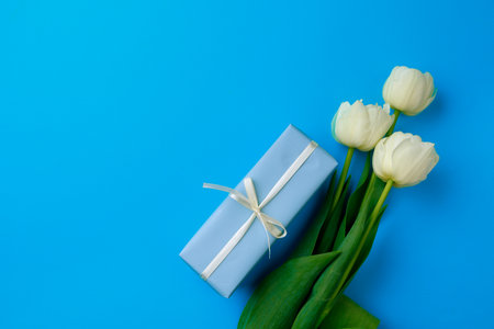 Gift box and Spring flowers on color background. Happy womens day. Happy Mothers day.Hello Spring