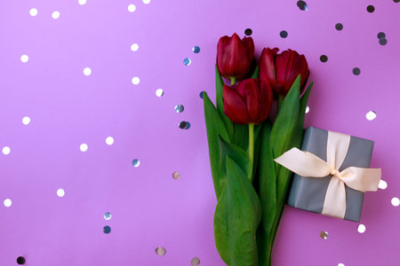 Gift box and spring flowers with confetti  on color background. Stylish soft image of spring flowers. Happy womens day. Happy Mothers day.Hello Springの写真素材