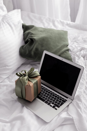 laptop and gift on the bed top view