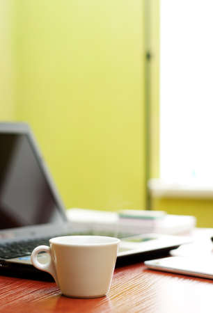 Close-up of coffee cup standing on office tableの写真素材