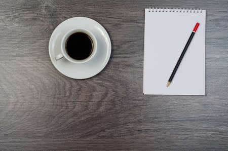 Notebook, coffee and smartphone on a wood desk.
