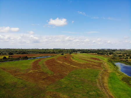 Green beautiful meadows in the river valley. Photo taken from a professional drone.