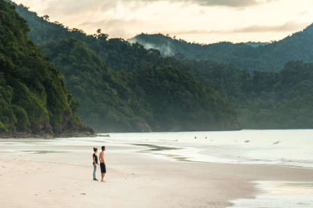 Man and Woman are overlooking the shores of the ocean.