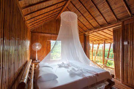 Rural style bedroom with canopy bed , bamboo decorated. Very popular tourist resort area.のeditorial素材
