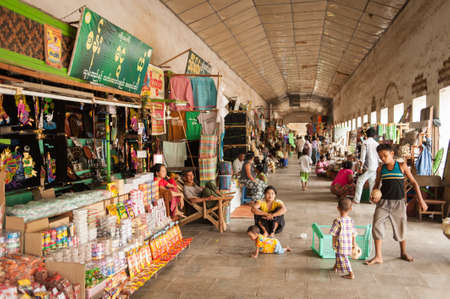 Mandalay, Myanmar - May 3 , 2013 : Young Burmese woman sitting on the street and selling food near...