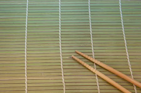 Two chopsticks on a bamboo mat backgroundの写真素材