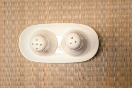 salt and pepper bottles on mat backgroundの写真素材