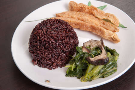 Vegetarian food Thai-style with Stir-fried vegetables spinac and shiitake, Riceberry rice, tamarind paste  and sour soup (Selective Focus, Focus on the Riceberry rice)の写真素材