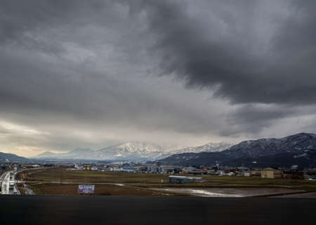 Deserted wet road leading into horizon under stormy sky in japan ,December 2016のeditorial素材